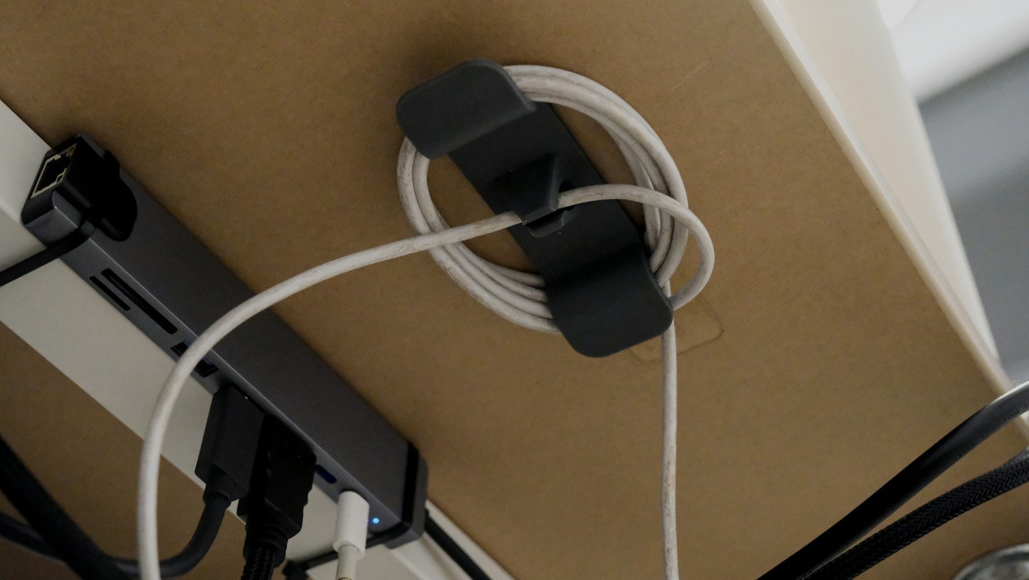 USB hub and cables secured to the underside of a desk