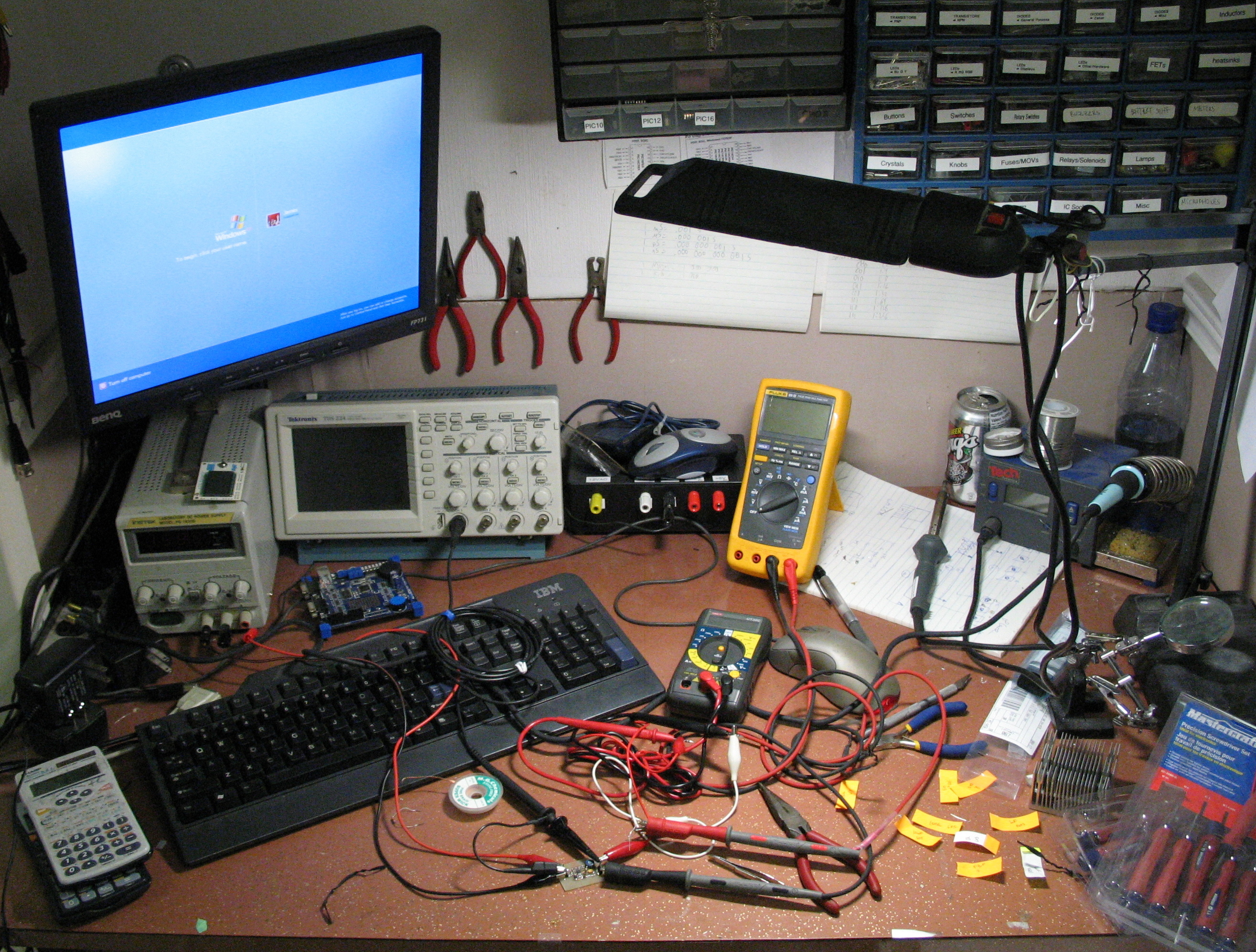An electronics workbench with tools and organized drawers